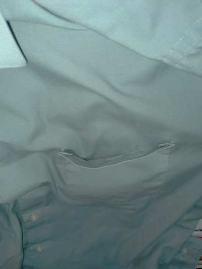 A shirt pocket. The left and right top corners have detached from the shirt